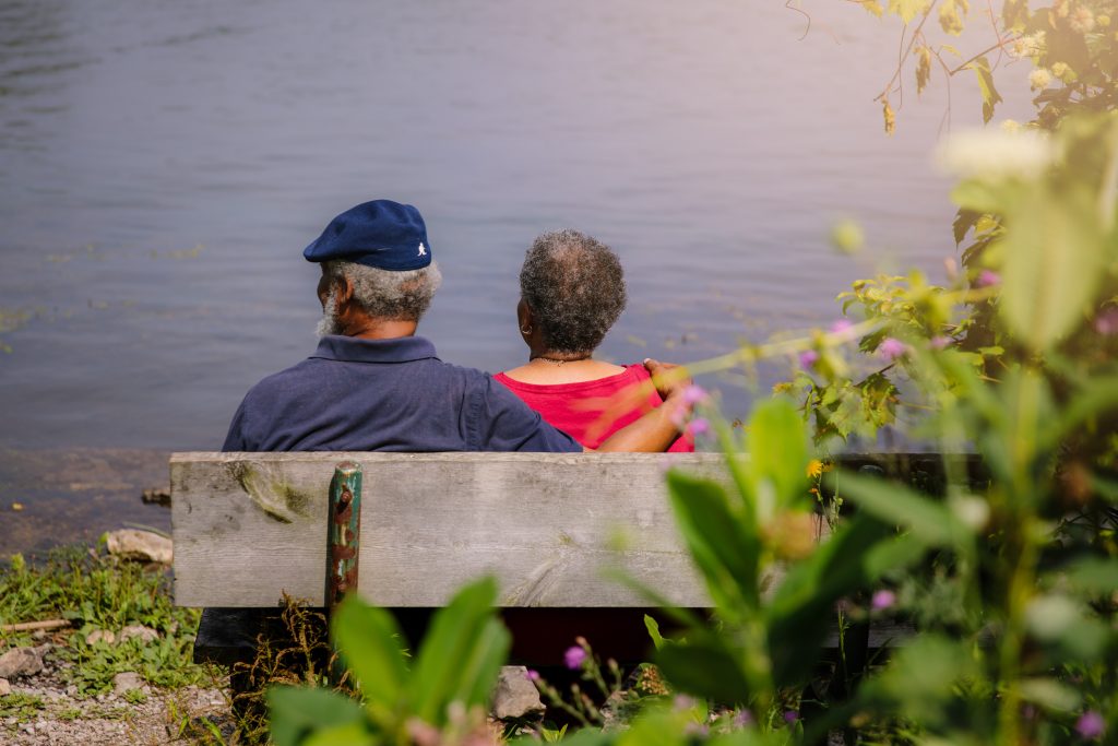 Couple sitting on a bench by the water