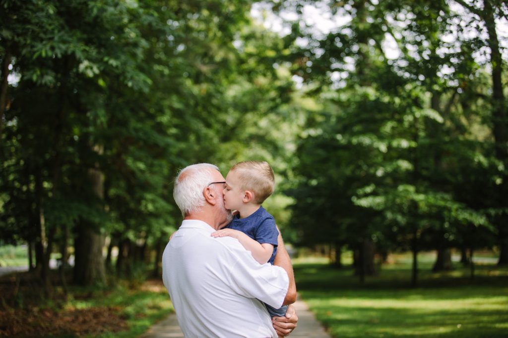 elderly man holding toddler boy