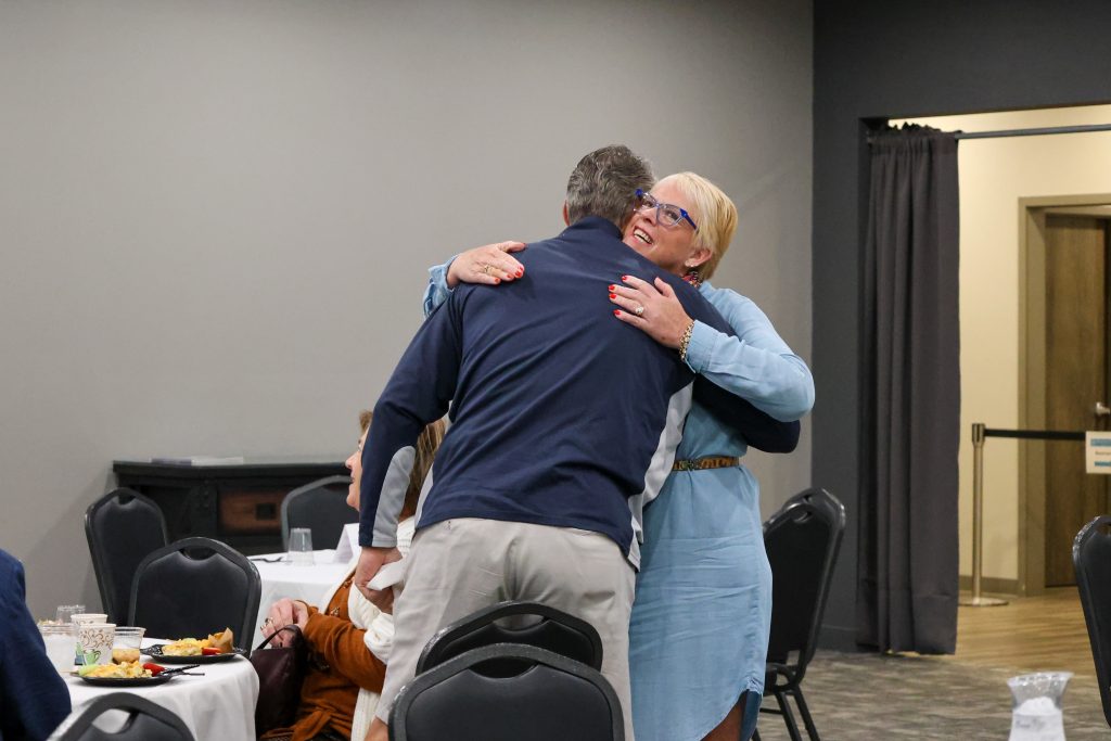 woman and man hugging at Harbor Hospice Foundation event