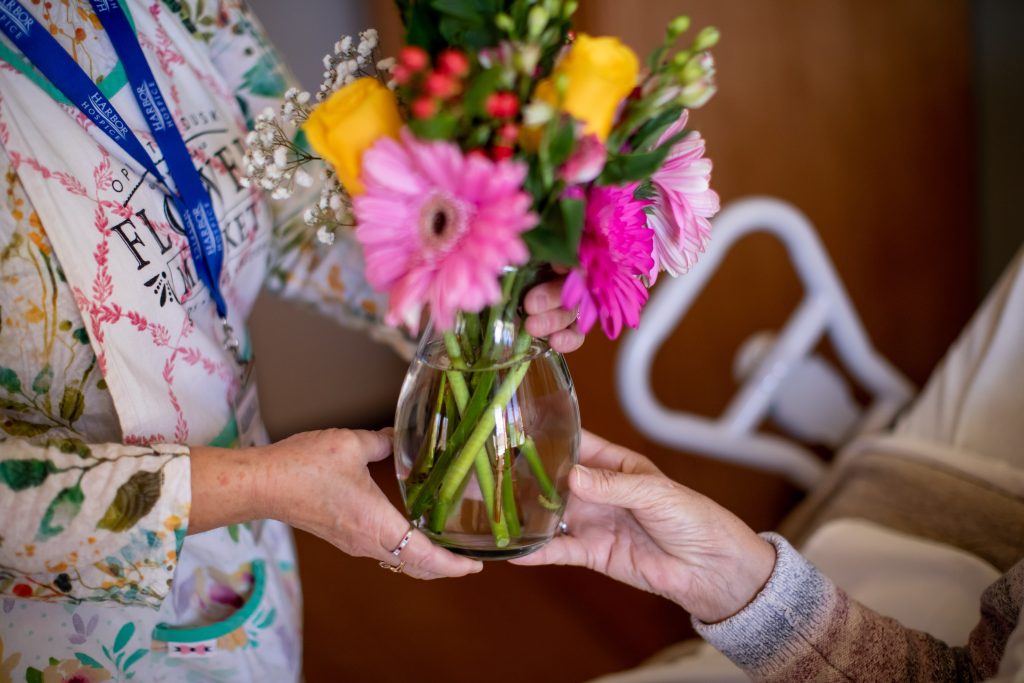 Vase of flowers being given to a Harbor Hospice patient