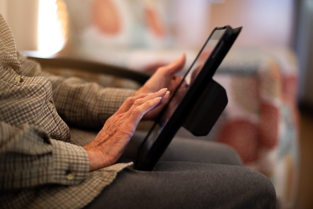 Older Harbor Hospice patient using a tablet