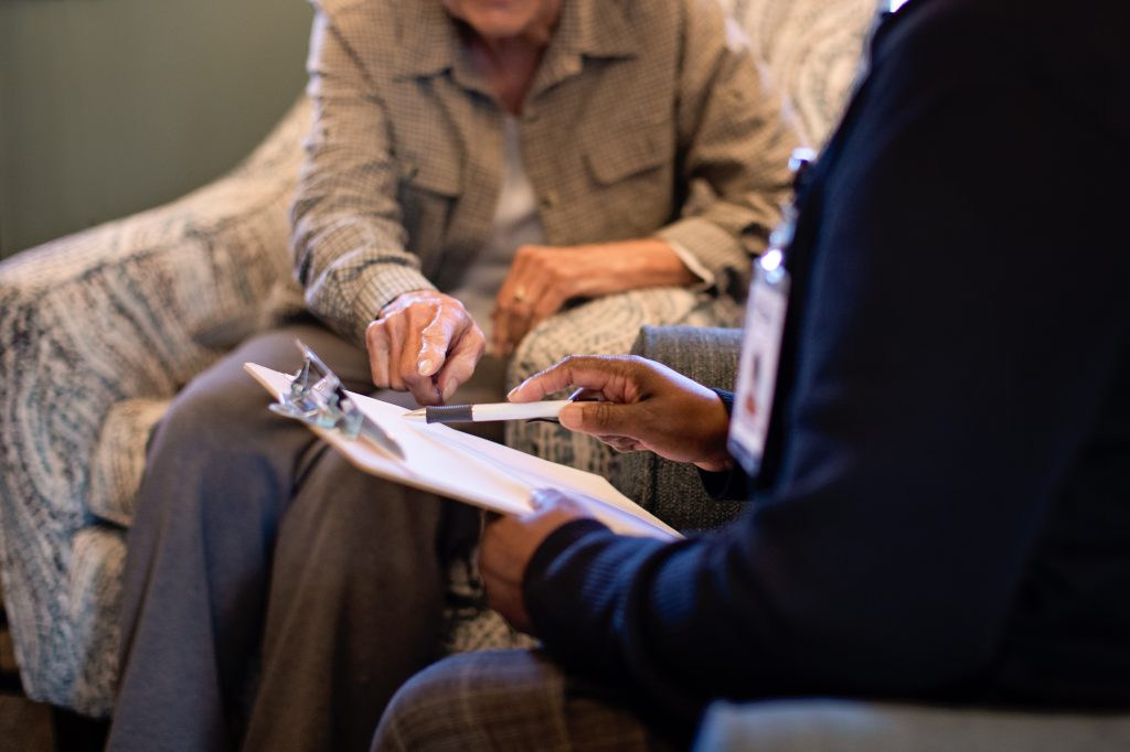 Harbor Hospice patient reviews paper work with Harbor Hospice staff