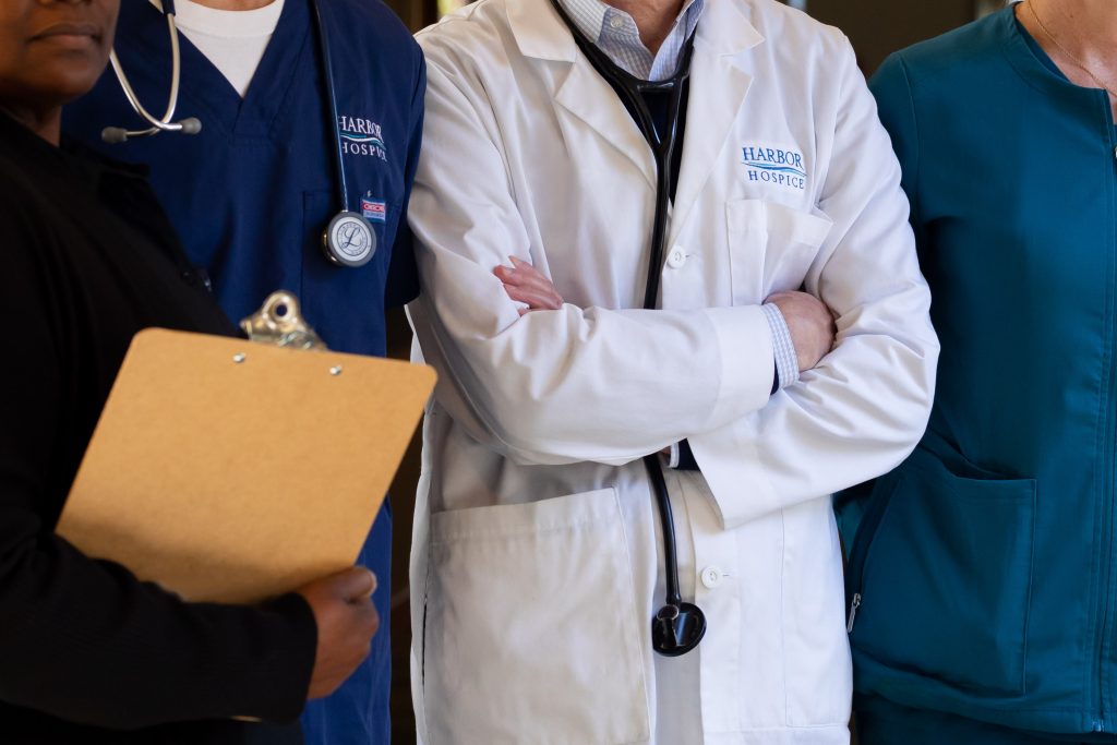 Harbor Hospice Staff gathered in a group wearing scrubs and lab coats