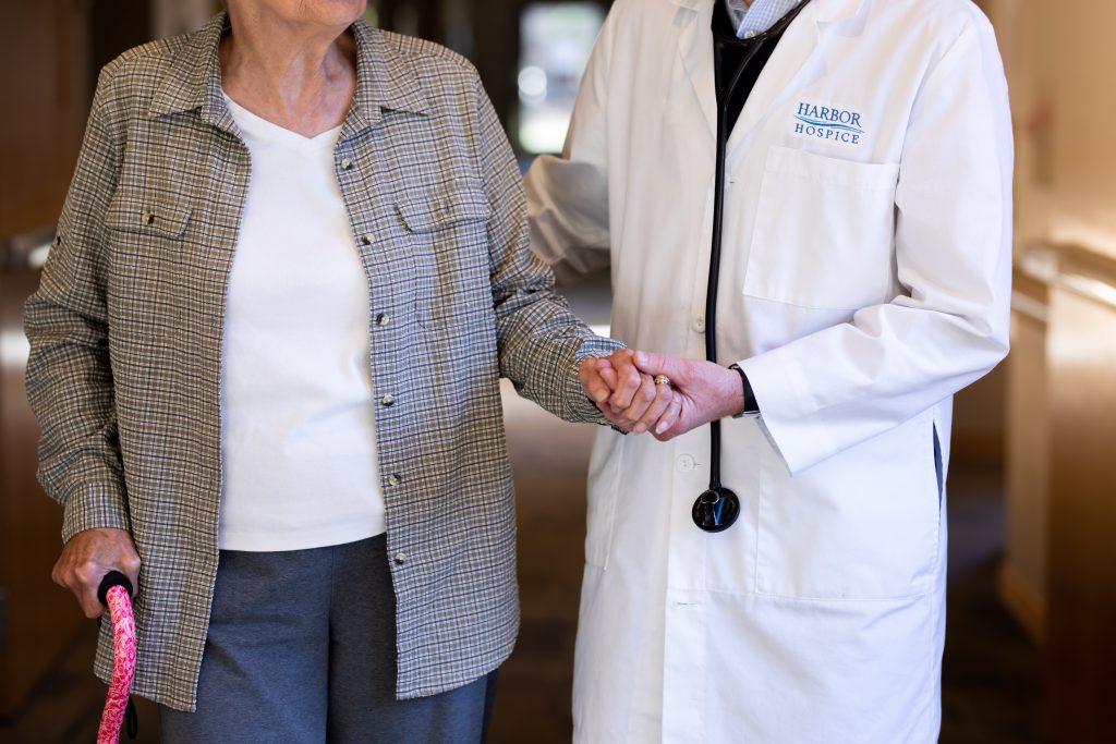 Harbor Hospice doctor walks with an older woman patient